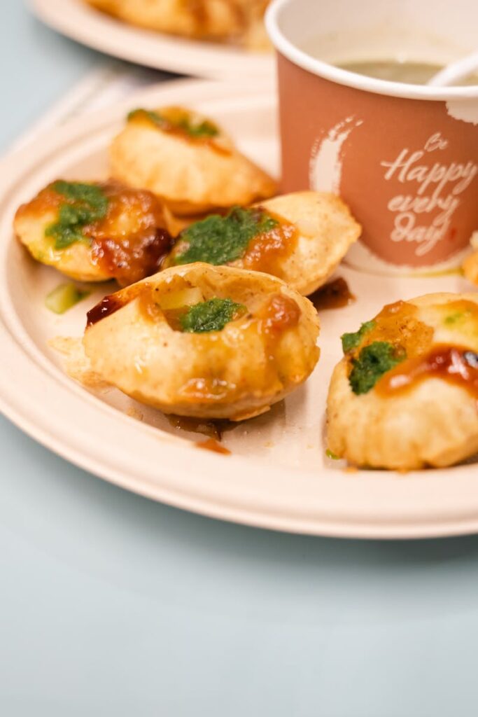 Home Close-up of flavorful Indian Pani Puri with chutney on a plate.